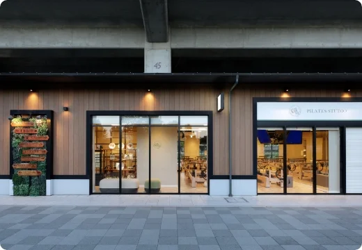 Pilates studio Caliaの店舗外観とガラス越しに見えるピラティスマシン