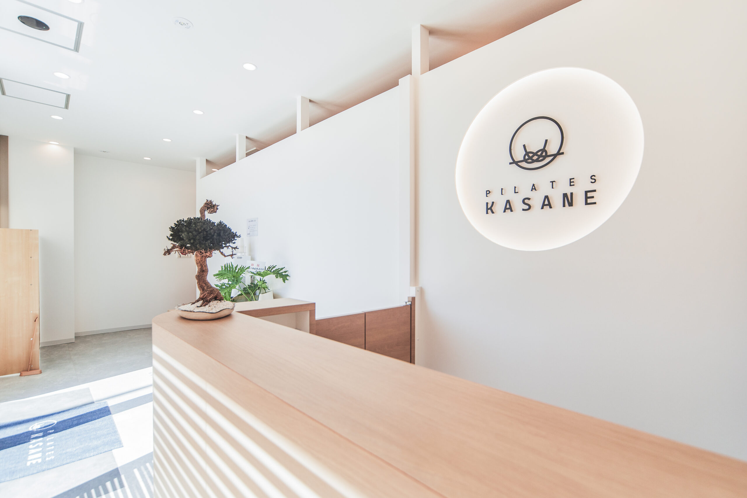 Pilates KASANE長崎店のロゴが掲示された受付カウンター