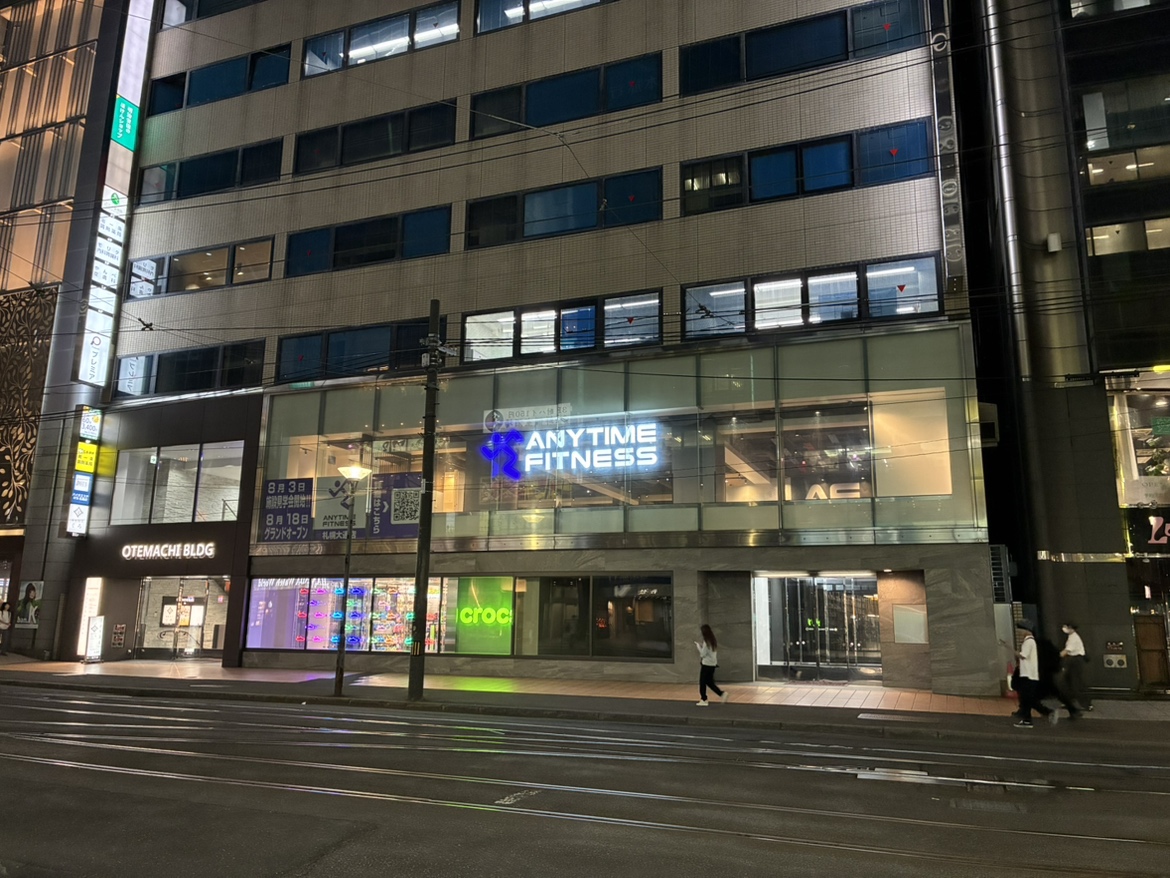 エニタイムフィットネス札幌大通店の夜間外観。札幌大手町ビル2階の看板と店舗窓面
