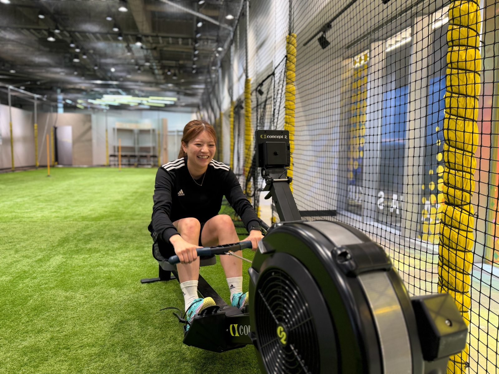 GYM FIELD 所沢スタジオの人工芝エリアでローイングマシンを使う様子